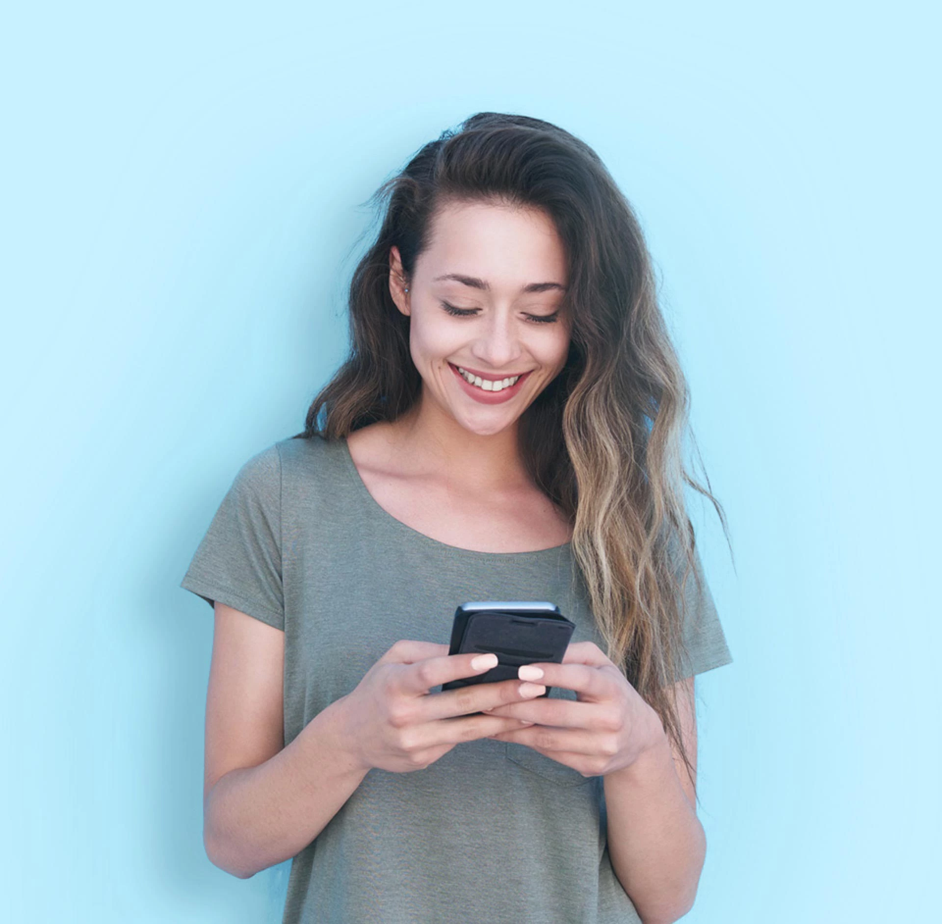 smiling woman using smartphone against blue background